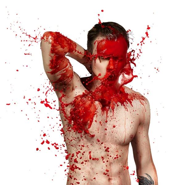 Bright splashes of red paint on a young guy.