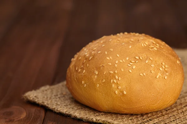 Bread bun for burger in sesame on wooden board