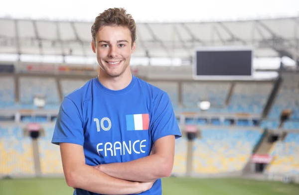 Young fan from France in sports jersey at soccer stadium