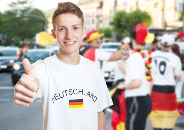 Laughing german fan showing thumb with other fans