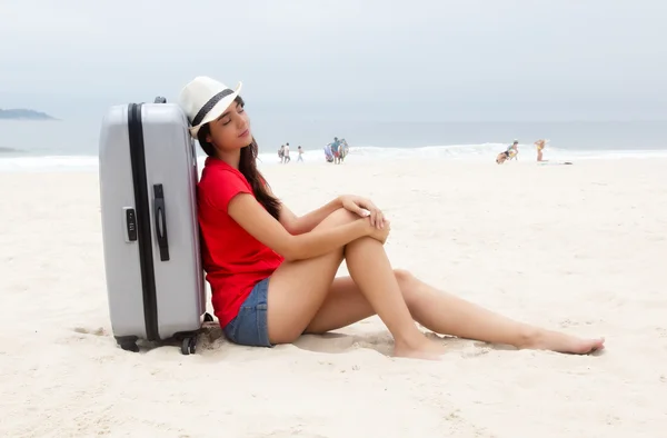 Caucasian female tourist with suitcase relaxing at beach