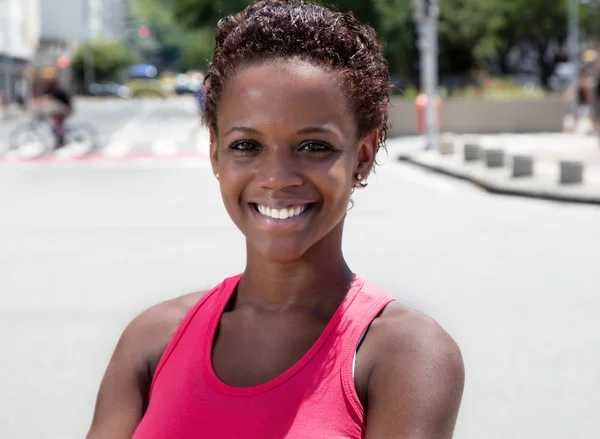 African american girl in pink shirt in city