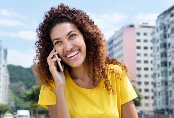 Beautiful mexican girl at phone outdoor in city