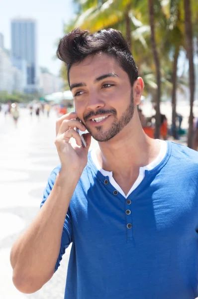 Brazilian guy with mobile phone at Aveniada Atlantica at Rio de