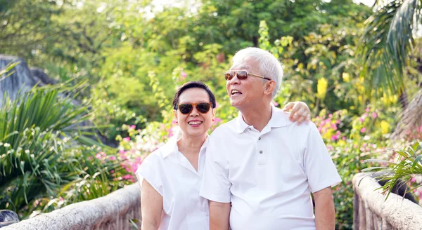 Asian senior with green tropical nature background at morning sun