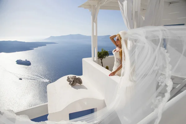 Beautiful young couple in wedding dress with a long veil Santorini