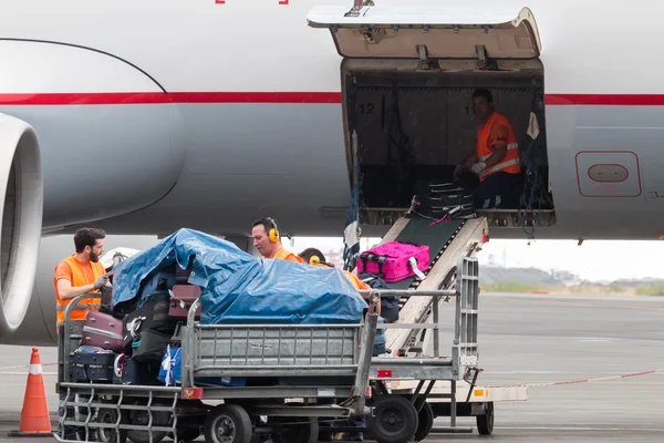 People loading luggage on the plane to the airport macedonia a r
