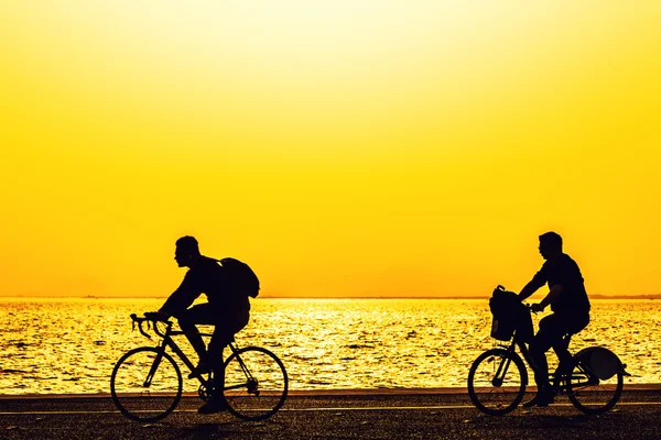 Silhouettes of people enjoying a walk by the seaside of the town