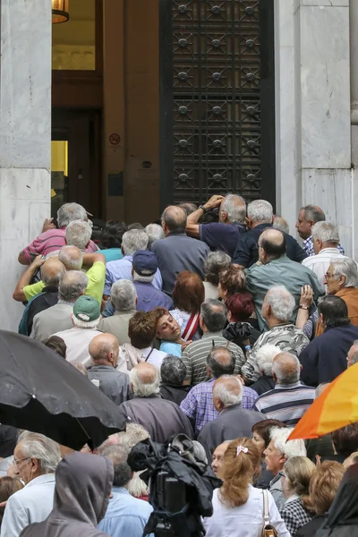 Pensioners queue outside a National Bank branch as banks only op