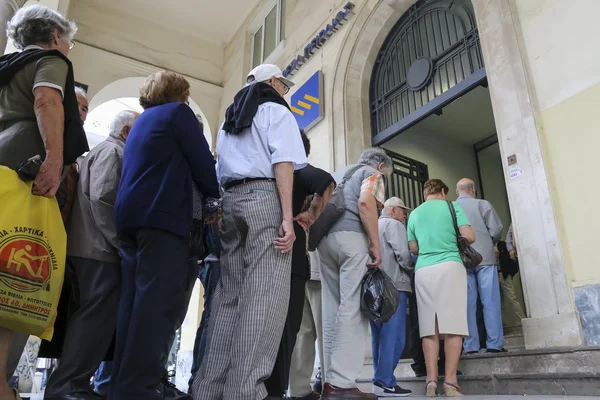 Pensioners queue outside a National Bank branch as banks only op