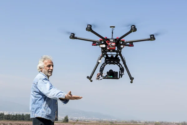Man watches DJI S900 drone in flight with a mounted sony A7 Edit