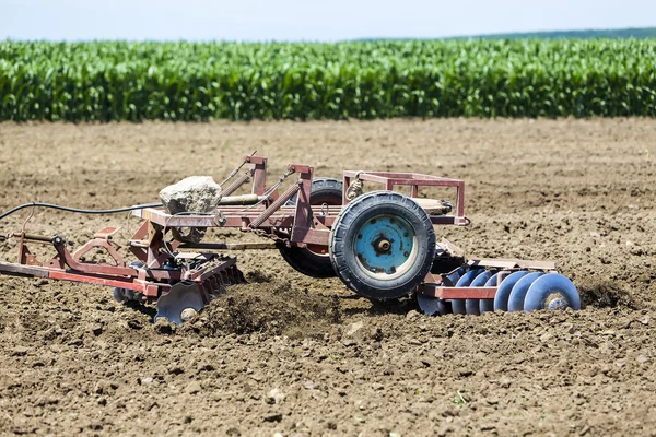 A tractor working planting wheat in the fertile farm fields of G