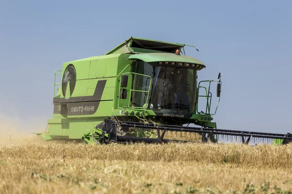 Combine harvester harvesting wheat on sunny summer day in Greece