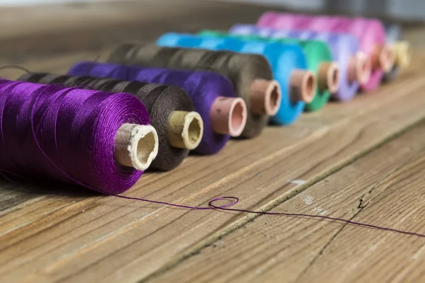 Spools of thread on wooden background. Old sewing accessories. c