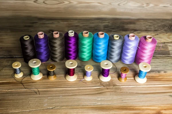 Spools of thread on wooden background. Old sewing accessories. c