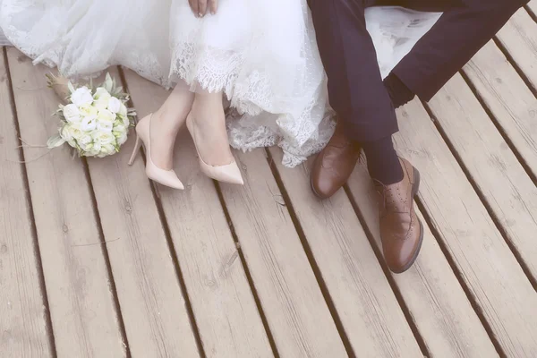 Feet of bride and groom, wedding shoes (soft focus). Cross proce