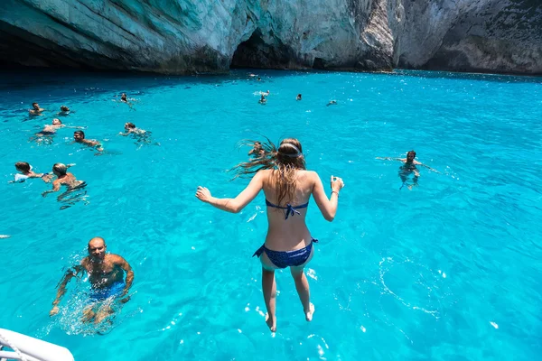 Tourists enjoying the clear water of Zakynthos island, in Greece