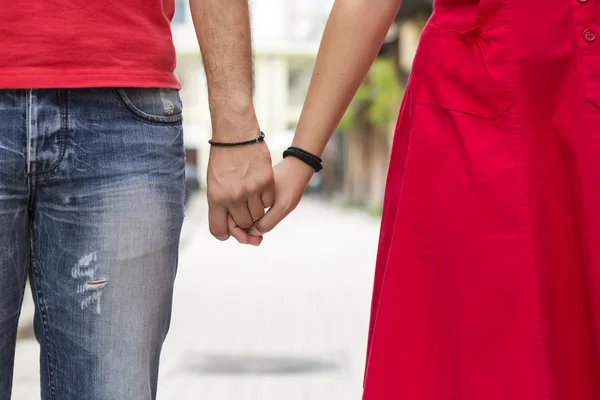 Young couple holding hands on the street together