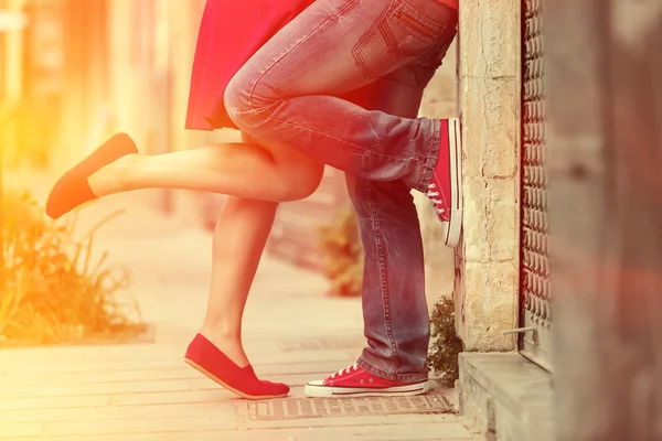 Young couple kissing outdoor. Male and female legs. Cross proces