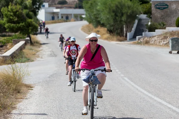 People going by bike in the city in Milos, Greece. A lot of tou