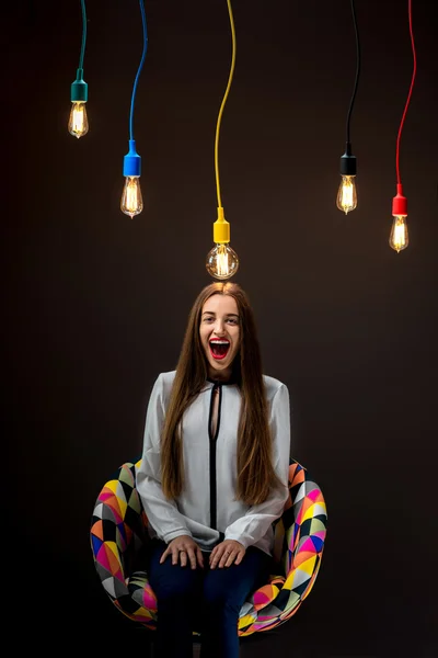 Woman sitting on the chair with colorful lamps