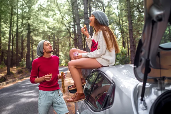 Young couple traveling by car in the forest