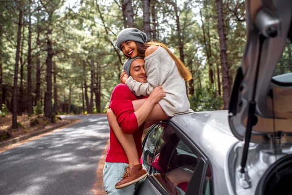 Young couple traveling by car in the forest