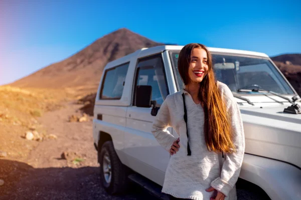 Woman traveling rocky landscape by jeep