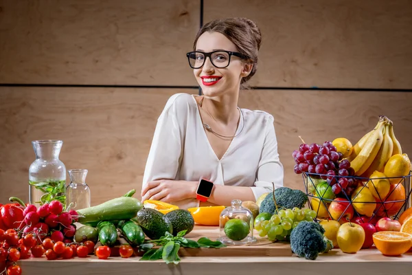 Young woman with fruits and vegetables in the kitchen