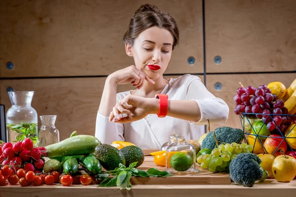Young woman using smart watch in the kitchen