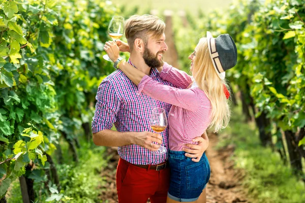 Couple having fun with glasses of wine on the vineyard