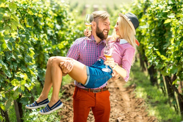 Couple having fun with glasses of wine on the vineyard