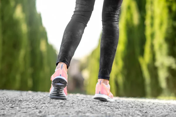 Female legs in sport sneakers