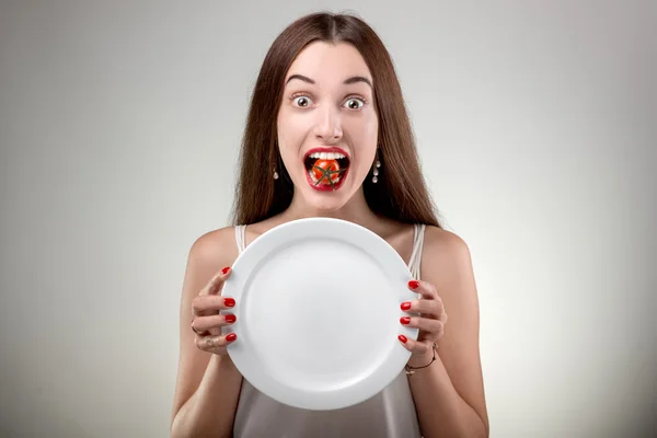 Young woman showing empty plate.