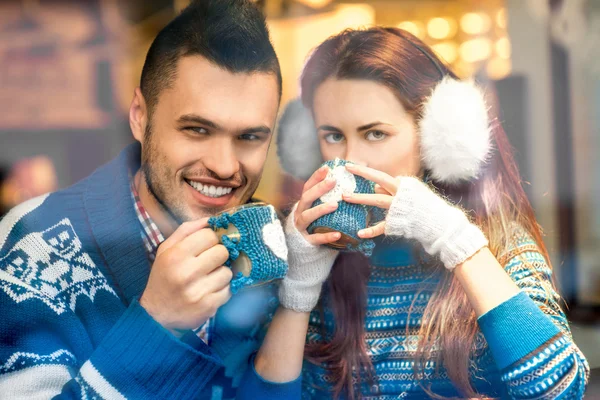 Young couple with coffee at the cafe in winter