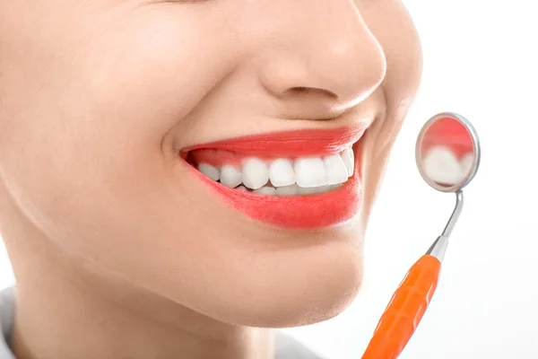 Woman with dental mirror on white background