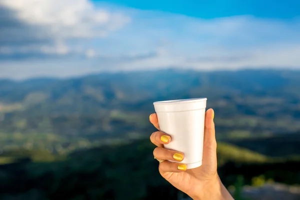 Holding white paper coffee cup