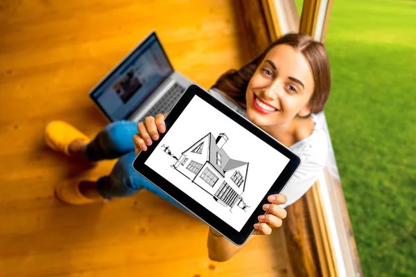 Woman showing digital tablet in the wooden house