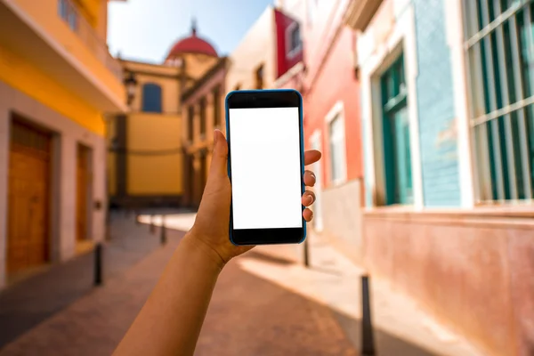 Smartphone with white screen on the old town street background