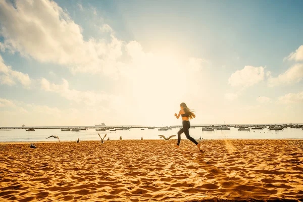 Woman running on the sandy beach