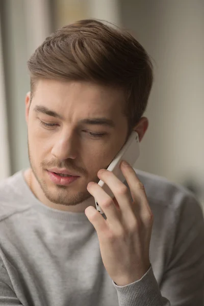 Young handsome man is talking by the phone