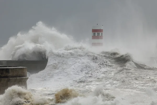 Waves covering piers and lighthouse