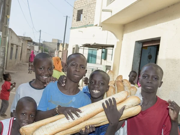 Editorial caption, Thiaroye, Senegal, Africa, July 28, 2014, Unidentified children (bread delivery boys) in the street, popular district of Guinaw Rails