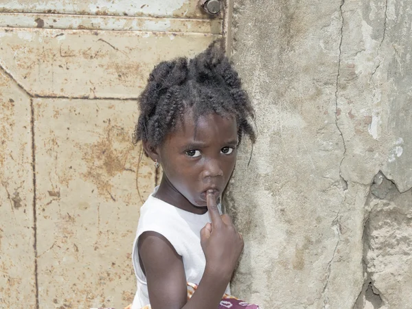 Editorial caption, Thiaroye, Senegal, Africa, July 26, 2014, Unidentified Senegalese girl in front of a house door, popular district of Guinaw Rails