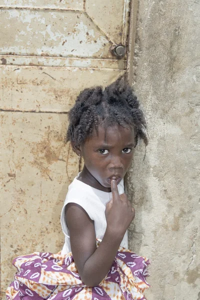 Editorial caption, Thiaroye, Senegal, Africa, July 26, 2014, Unidentified Senegalese girl in front of a house door, popular district of Guinaw Rails