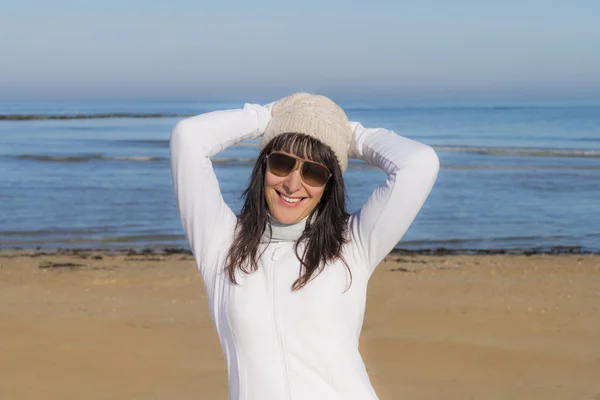 Happy middle-aged woman smiling at the beach