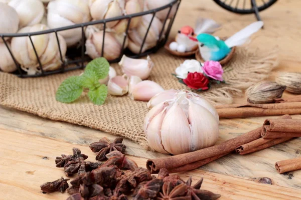Raw garlic has health benefits on wood background.