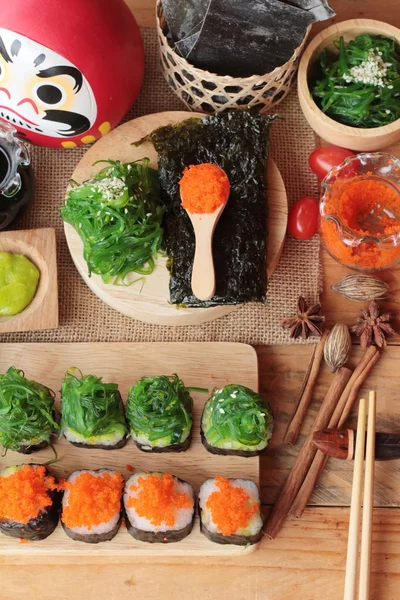 Sushi roll with seaweed salad and shrimp eggs