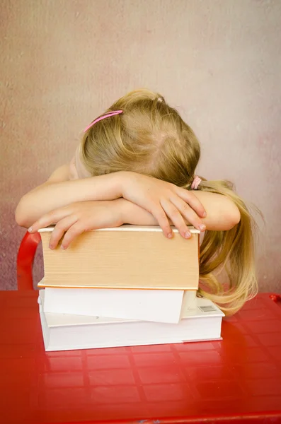 Girl hidden behind pile books