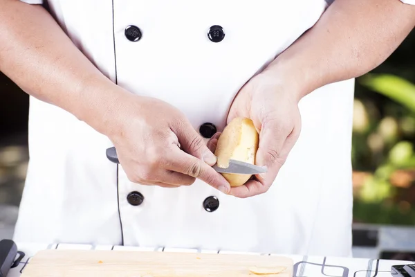 Chef peeling Potato with knife